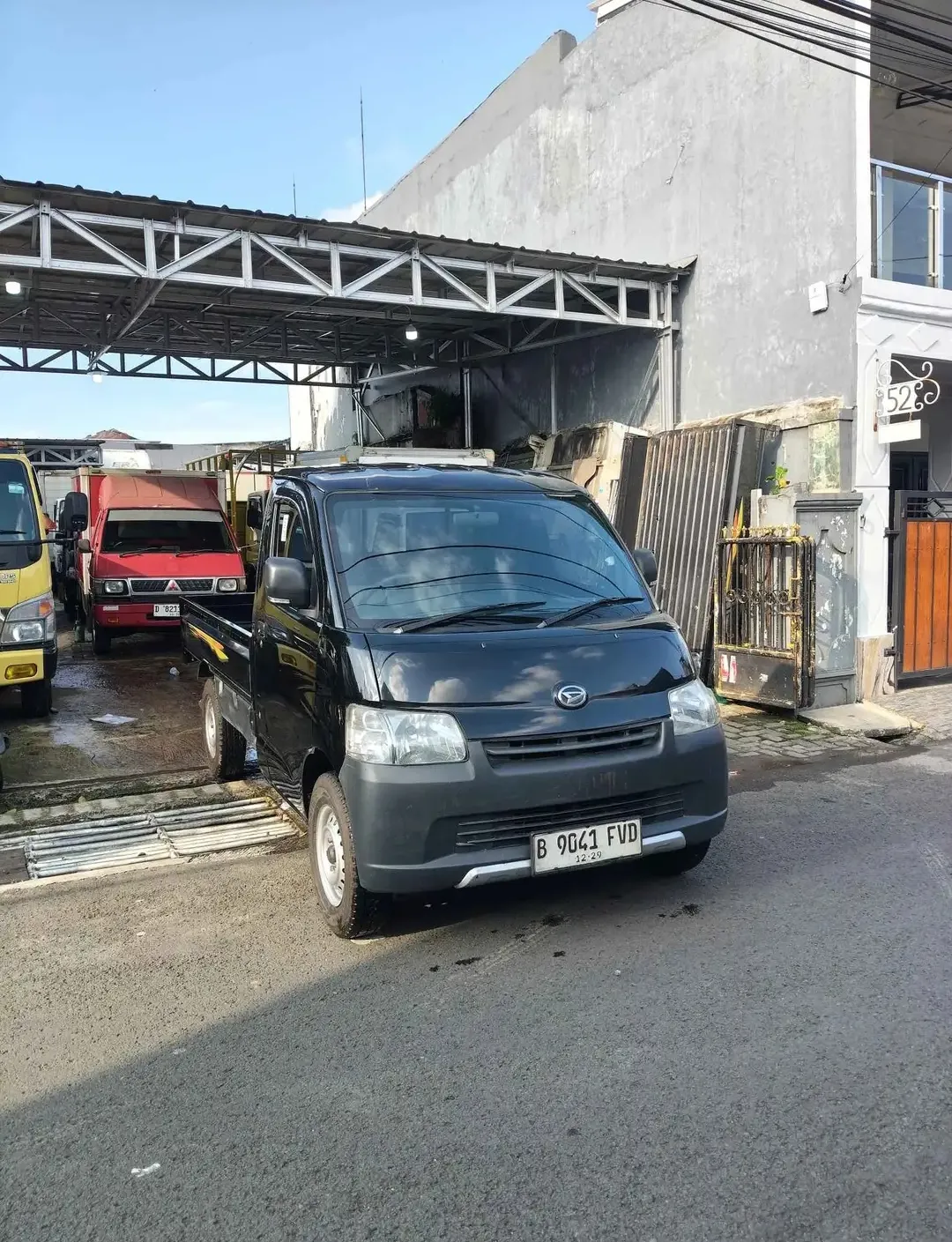 Armada pickup Daihatsu Gran Max hitam tampak dari sisi depan di area operasional.