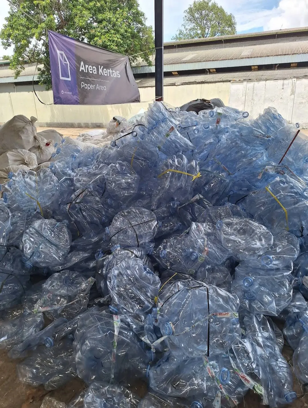 Botol plastik bening telah dikelompokkan di area material terpilah.