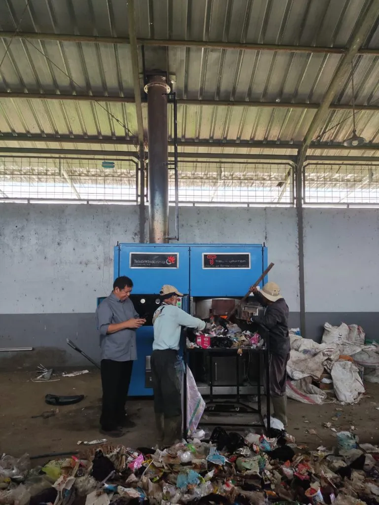 Petugas mengoperasikan mesin pengolahan residu Tel-Urator di dalam fasilitas.