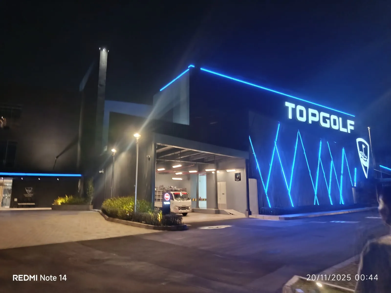 Armada angkutan sampah memasuki area layanan Topgolf Jakarta pada malam hari.
