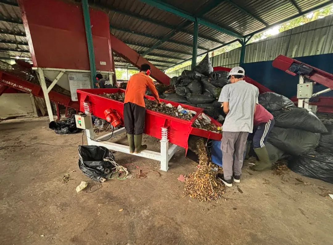 Petugas mengoperasikan meja getar untuk membantu pemilahan material.