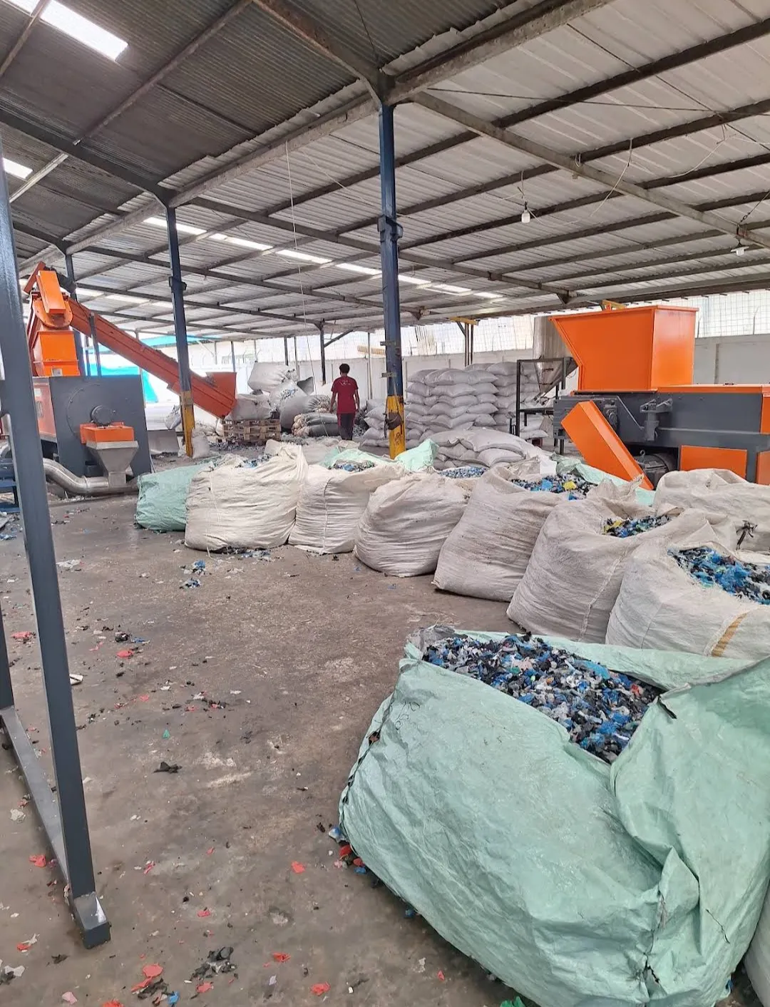 Mesin pengolahan dan karung material plastik berada di fasilitas pemilahan.